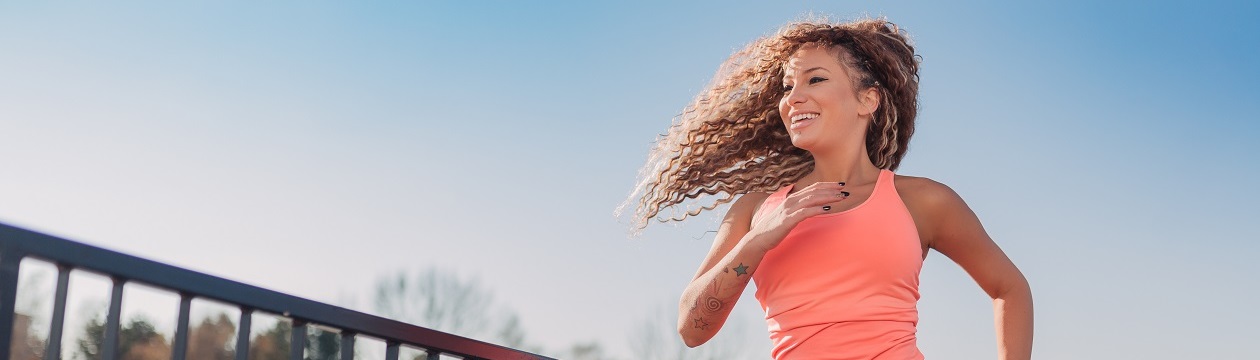 Young attractive woman enjoying outdoor physical exercise in an urban setting on a sunny day